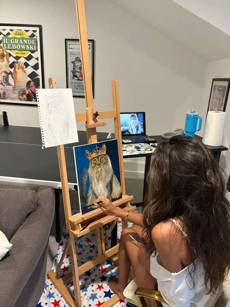 Sophi painting the crowned cat commission at her easel